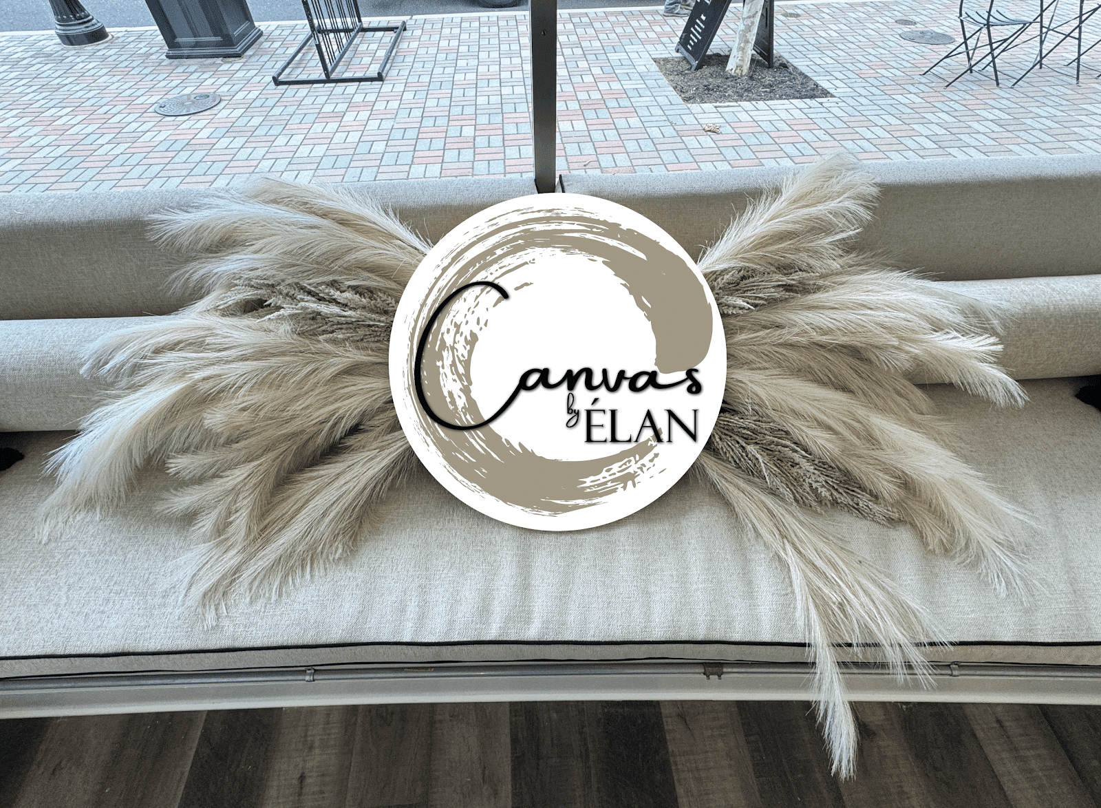 Dry grasses and decorative logo on a light-colored couch in a modern setting.